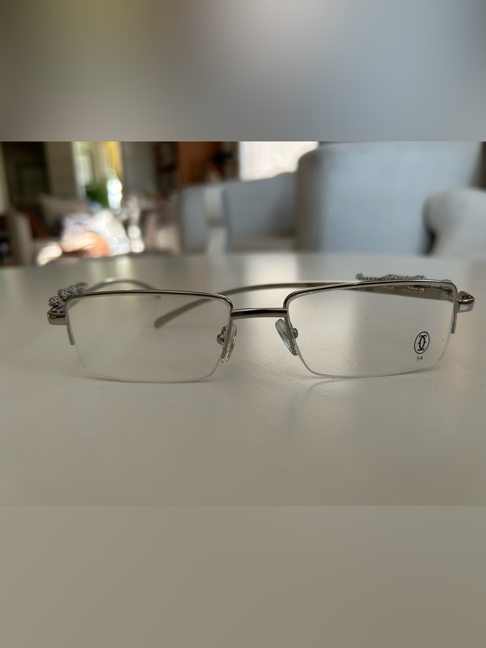 Minimalist Silver Rimless Rectangle Glasses with studded jaguar emblem.